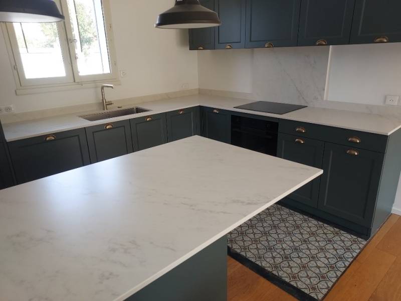 Réalisation Hm déco avec un dekton Marina sur une cuisine avec un ilôt et des meubles de cuisine bleu près de L