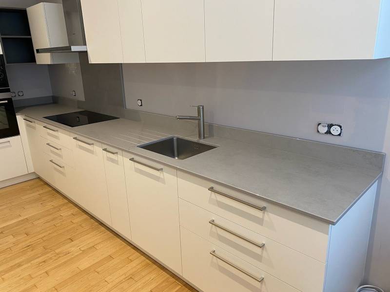 Faire poser des plans de travail gris clair dans une cuisine moderne avec des meubles blancs autour de Martillac 33