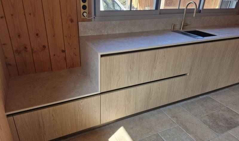 Plan de travail en Dekton Sabbia en escalier sur une cuisine en bois en Gironde 33