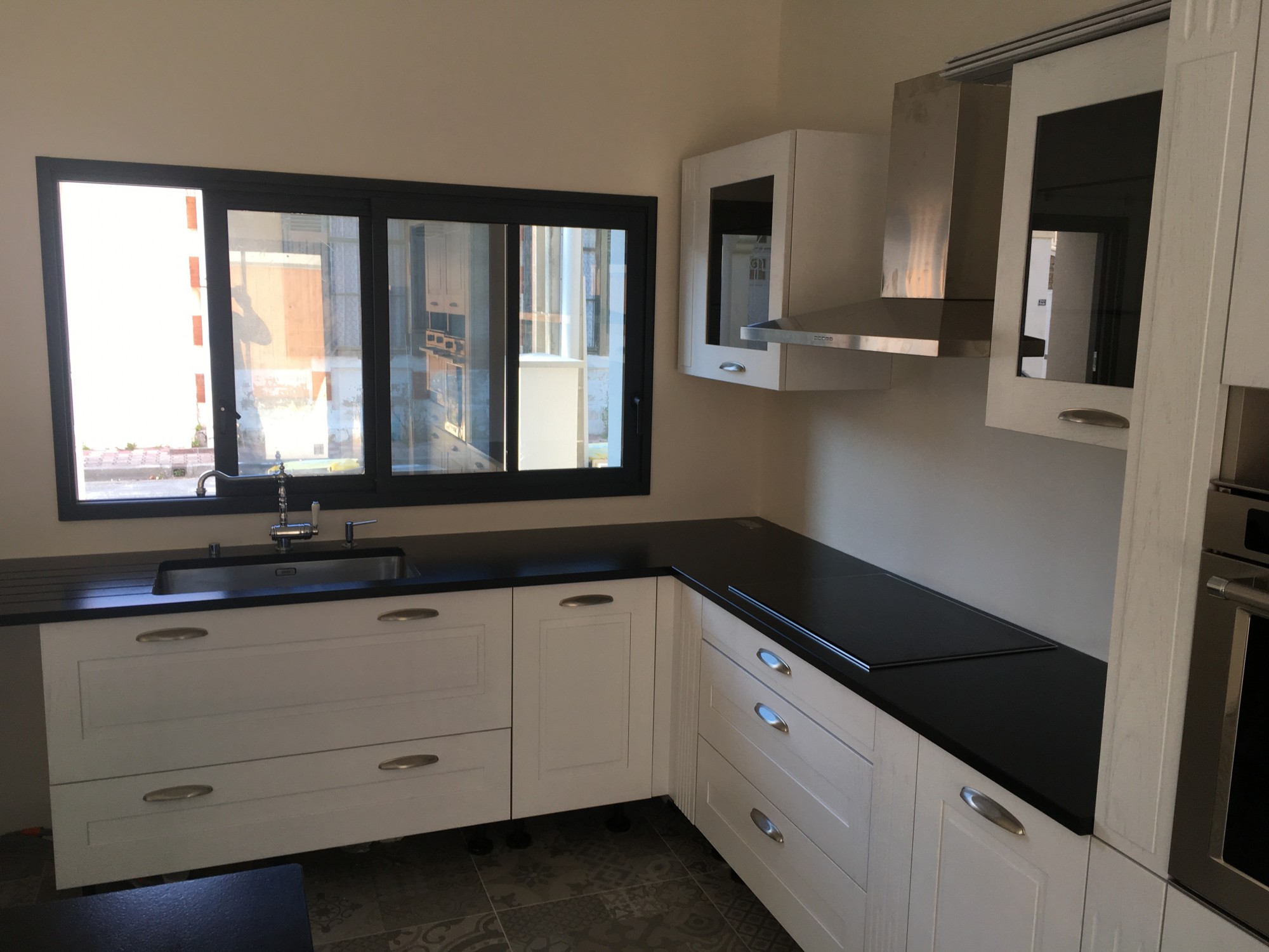 Poser un plan de travail noir sur des meubles de cuisine en bois blanc en Nouvelle Aquitaine