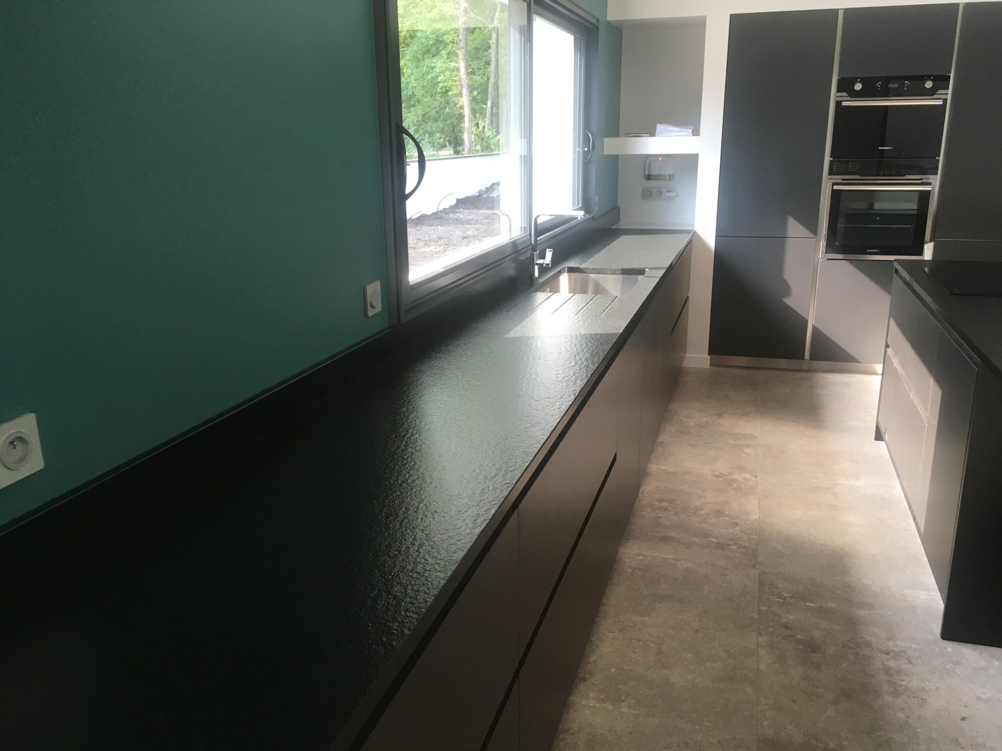 Plans de travail en pierre foncés dans une cuisine en aquitaine